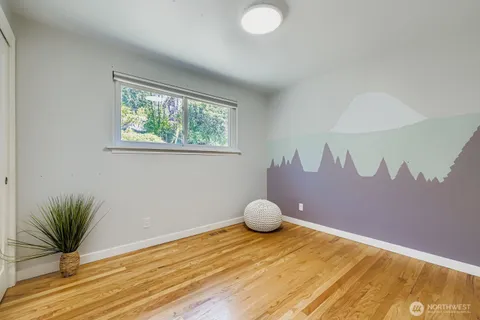 a view of a room with wooden floor and a potted plant