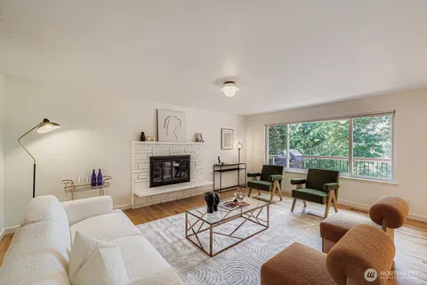 a living room with furniture fireplace and a large window