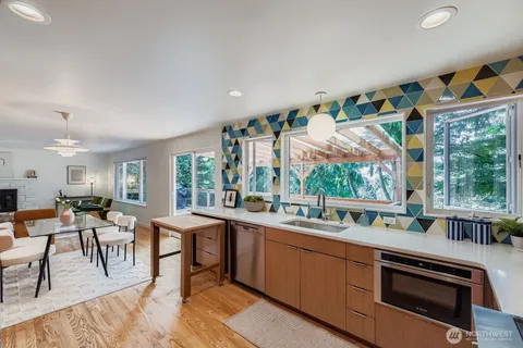 a kitchen with stainless steel appliances granite countertop a stove a sink and a dining table