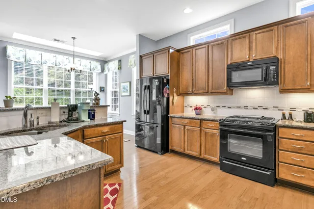 a kitchen with stainless steel appliances granite countertop a stove top oven a sink and dishwasher a oven with granite countertops