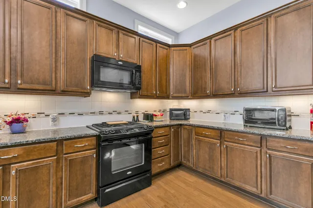 a kitchen with granite countertop cabinets stainless steel appliances and a sink