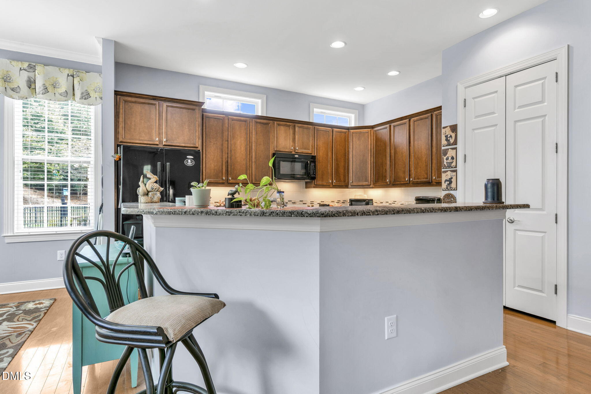 9805 Carlyle Hills Way Raleigh, NC 27560 - Photo 18 of 42 a kitchen with kitchen island granite countertop wooden cabinets and a stainless steel appliances