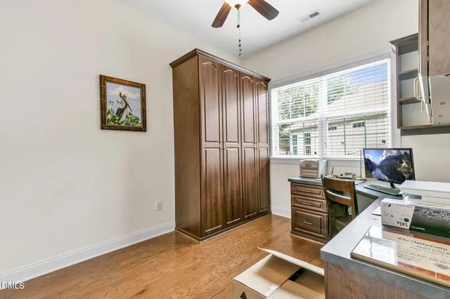 a view of a workspace with furniture and a window