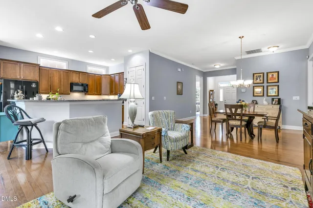 a living room kitchen with furniture and a dining table with wooden floor