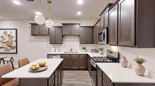 a kitchen with stainless steel appliances granite countertop a sink a stove and chairs