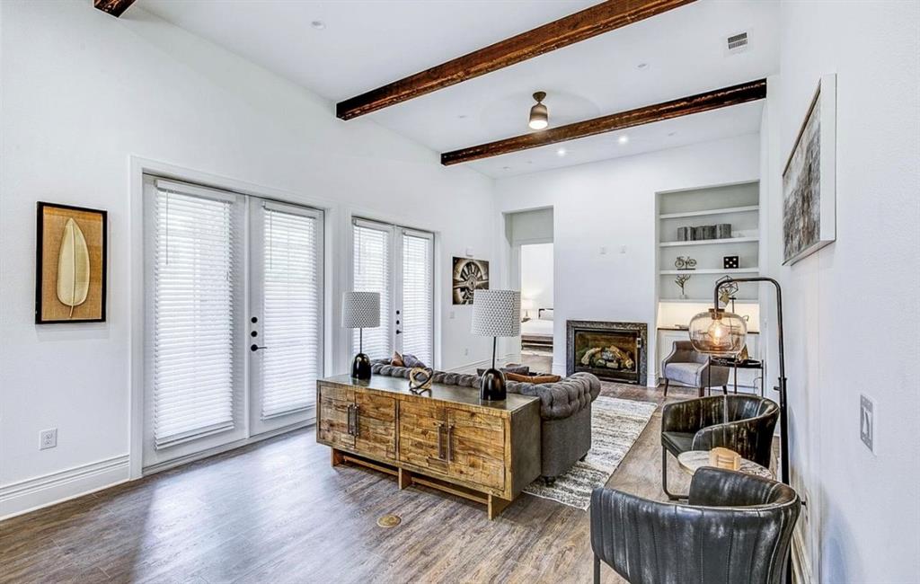 Living room with dark wood-type flooring, french doors, beam ceiling, and built in shelves
