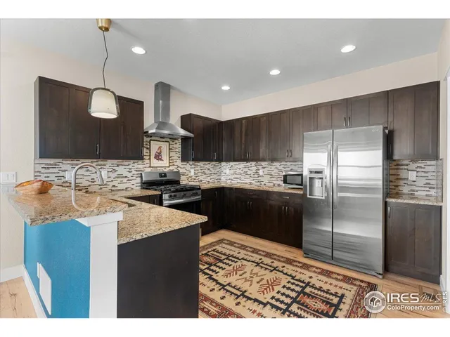 a kitchen with kitchen island granite countertop a sink stove and refrigerator