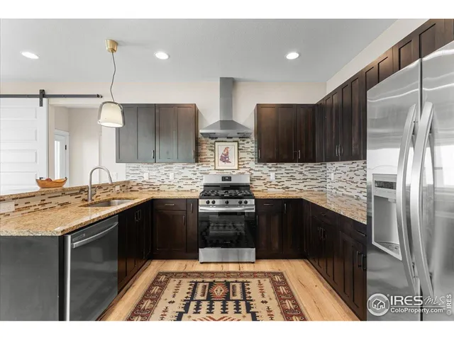 a kitchen with stainless steel appliances granite countertop a stove a sink and a refrigerator