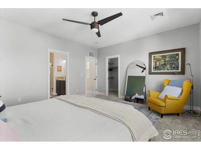 a bedroom with a bed a couch and a chandelier