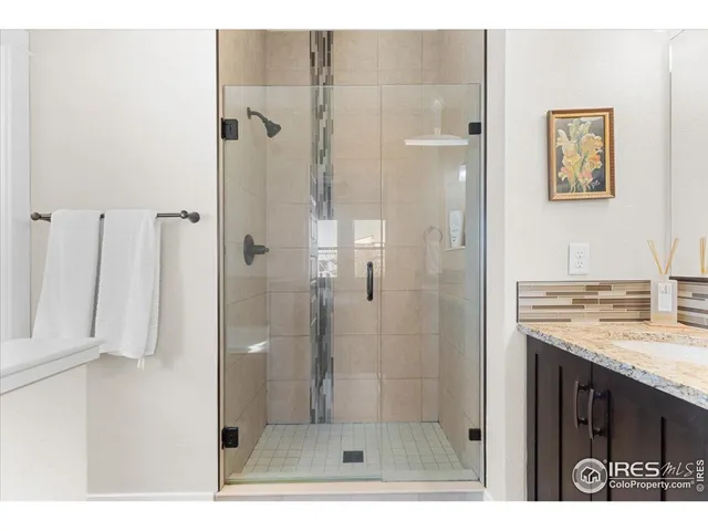 a bathroom with a granite countertop sink a shower and a mirror