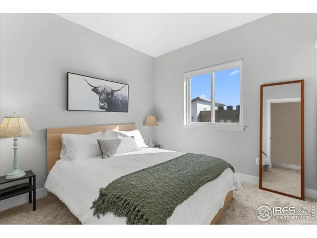 a bedroom with a bed and a painting on the wall