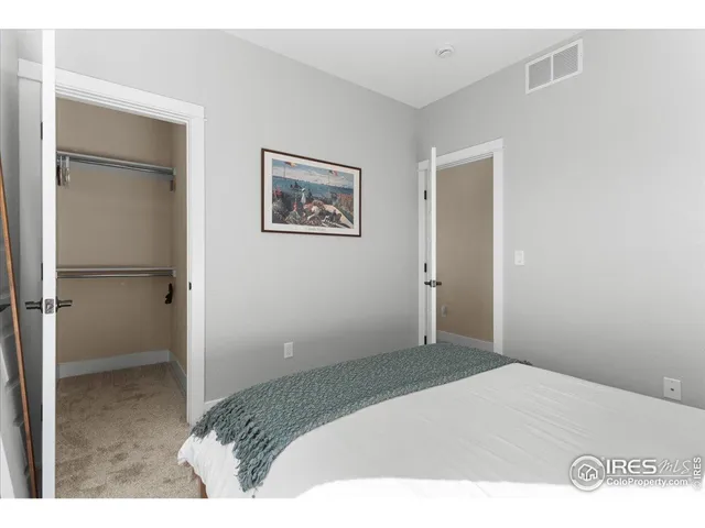 a bedroom with a bed and a painting on the wall