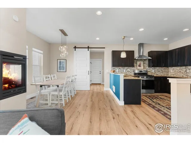 a living room with stainless steel appliances kitchen island granite countertop furniture wooden floor and a view of kitchen