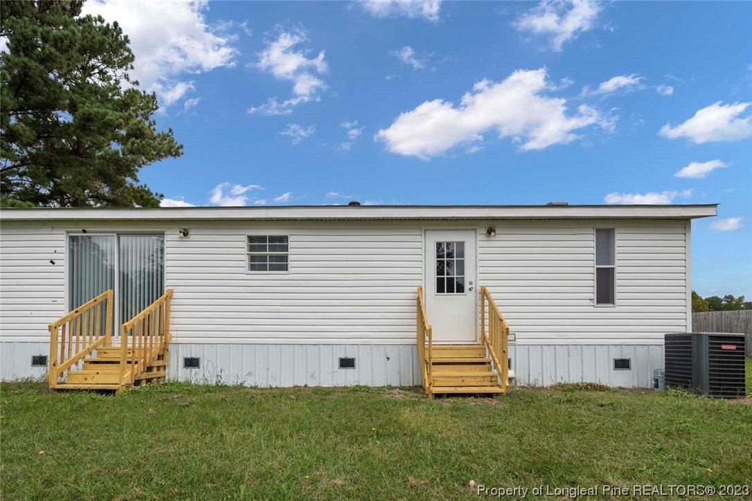 67 Apache Drive Parkton, NC 28371 - Photo 18 of 18 a view of a white house with a big yard and a large tree