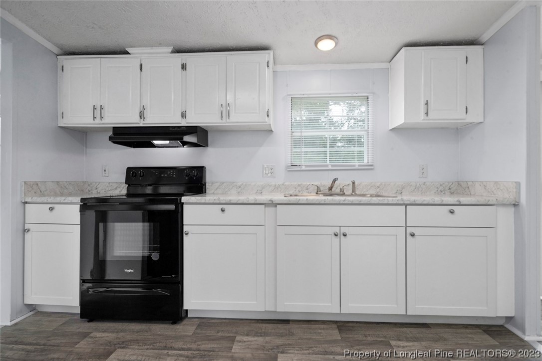 67 Apache Drive Parkton, NC 28371 - Photo 7 of 18 a kitchen with granite countertop white cabinets and stainless steel appliances