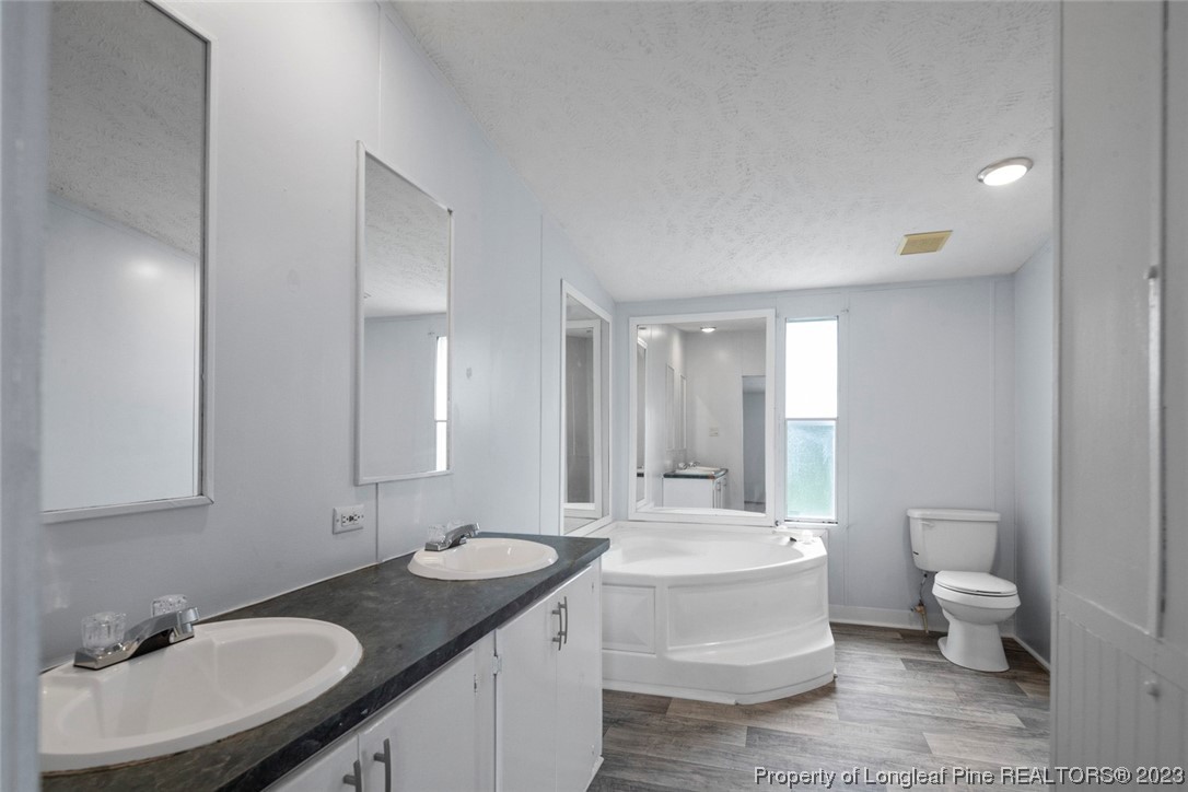67 Apache Drive Parkton, NC 28371 - Photo 10 of 18 a bathroom with a granite countertop sink and a mirror