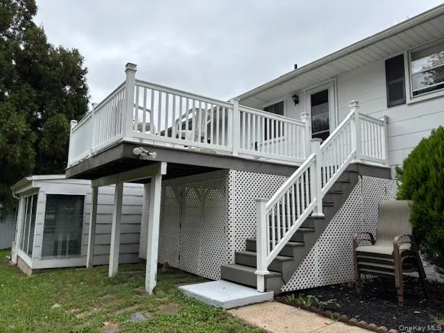 a view of a house with wooden deck stairs and a floor to ceiling window