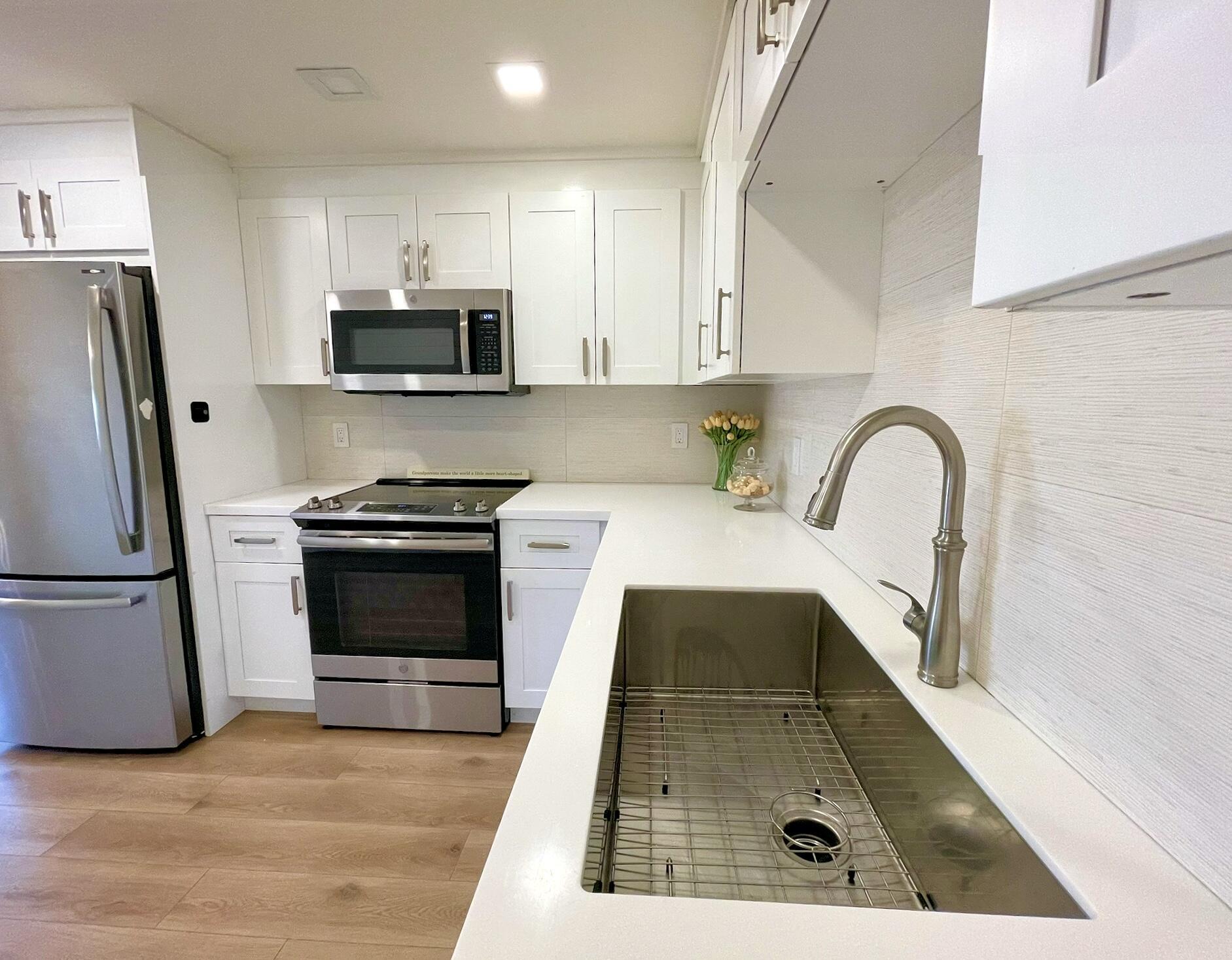 1030 Rexford B Boca Raton, FL 33434 - Photo 10 of 27 a kitchen with stainless steel appliances a stove a sink a microwave and refrigerator