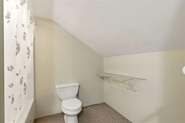 a white toilet sitting next to a shower curtain