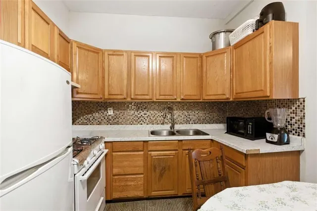 a kitchen with stainless steel appliances granite countertop a sink a stove and cabinets