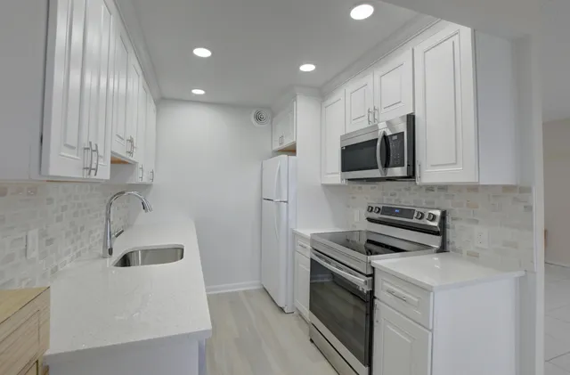 a kitchen with stainless steel appliances a stove microwave and sink
