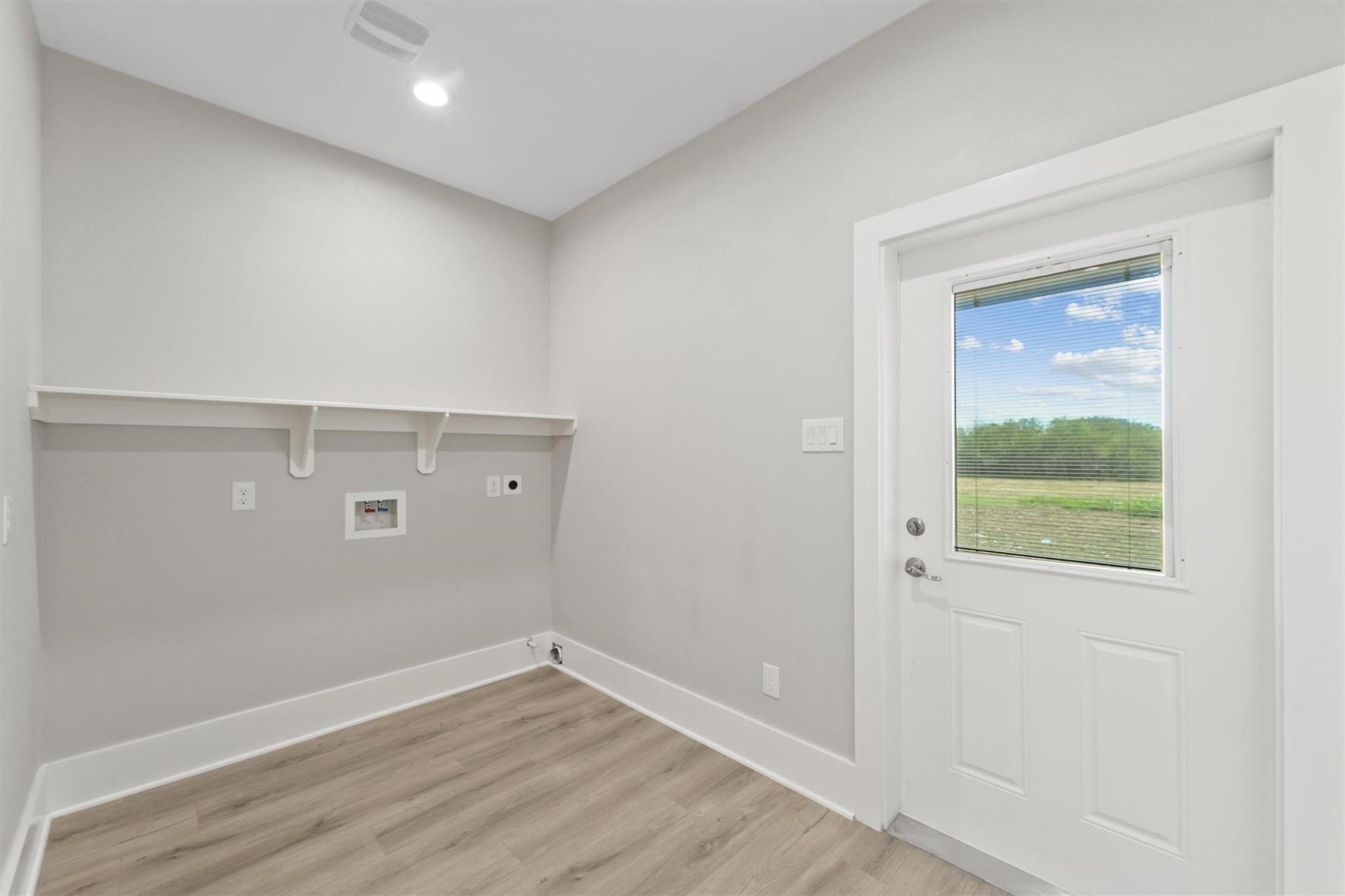 1900 Lezak Road Sealy, TX 77474 - Photo 16 of 34 a view of an empty room with wooden floor and a window