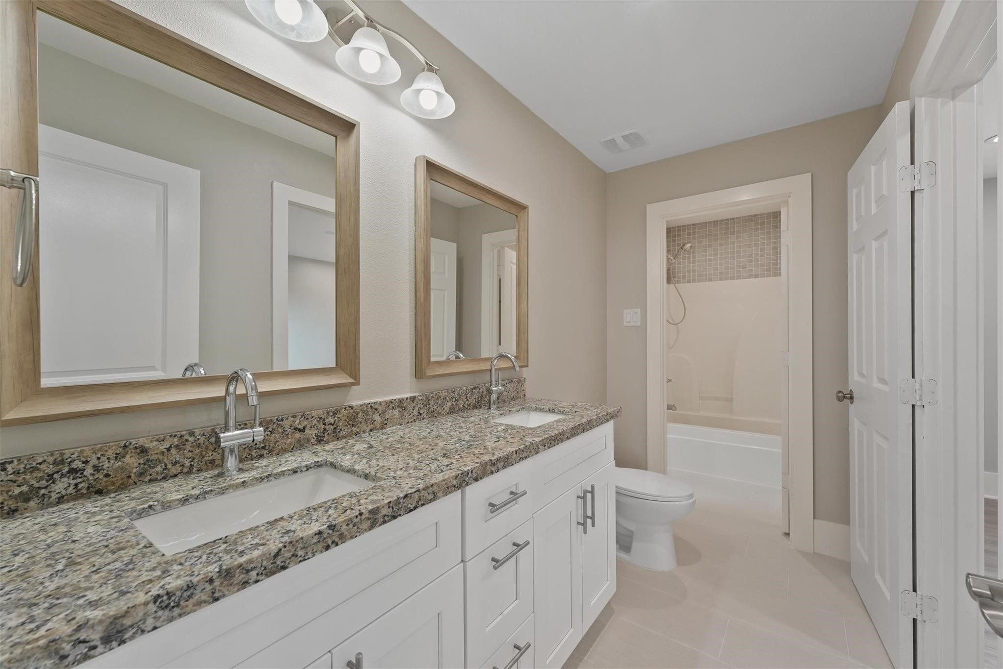 1900 Lezak Road Sealy, TX 77474 - Photo 21 of 34 a bathroom with a granite countertop sink a toilet and a shower