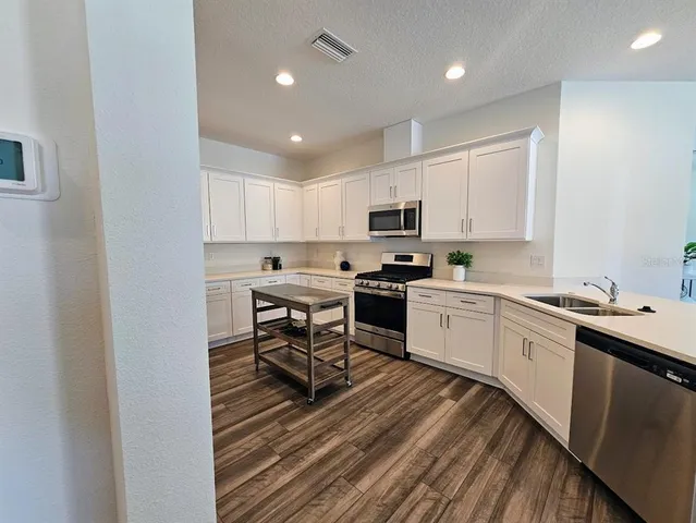 a kitchen with a sink microwave and cabinets