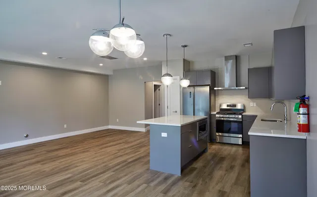 a kitchen with stainless steel appliances granite countertop a sink stove and wooden floor