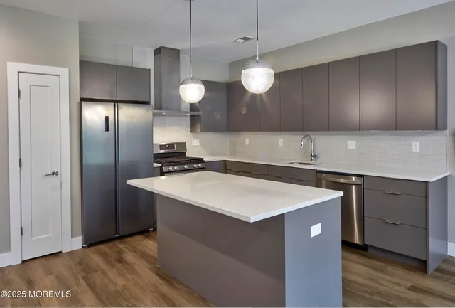 a kitchen with a sink a refrigerator and cabinets