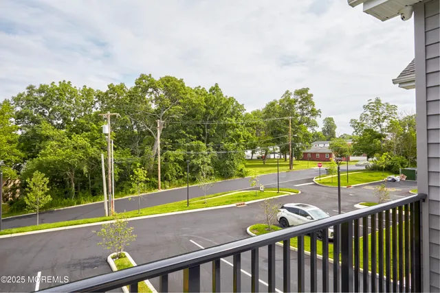 a view of a tennis court with a large tree in the background