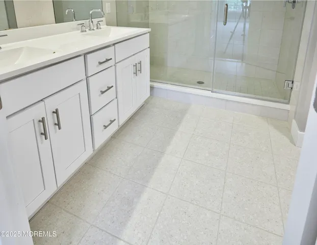 a bathroom with a sink a mirror and shower