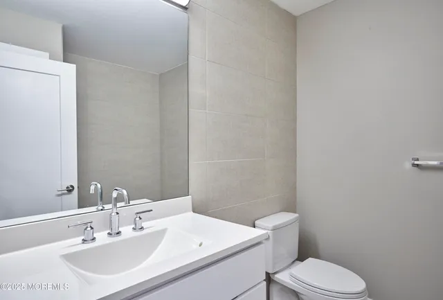 a bathroom with a sink a toilet and a mirror