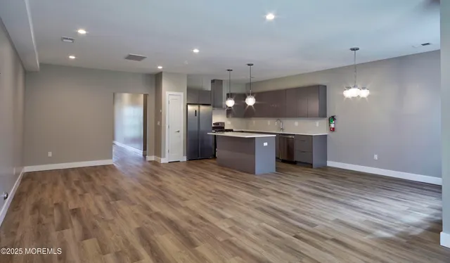 a view of kitchen with a sink wooden cabinets and stainless steel appliances