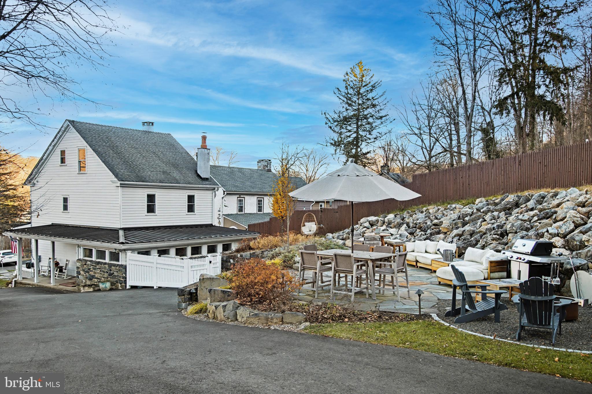 4934 River Road New Hope, PA 18938 - Photo 53 of 56 a view of a patio with table and chairs under an umbrella with a small yard