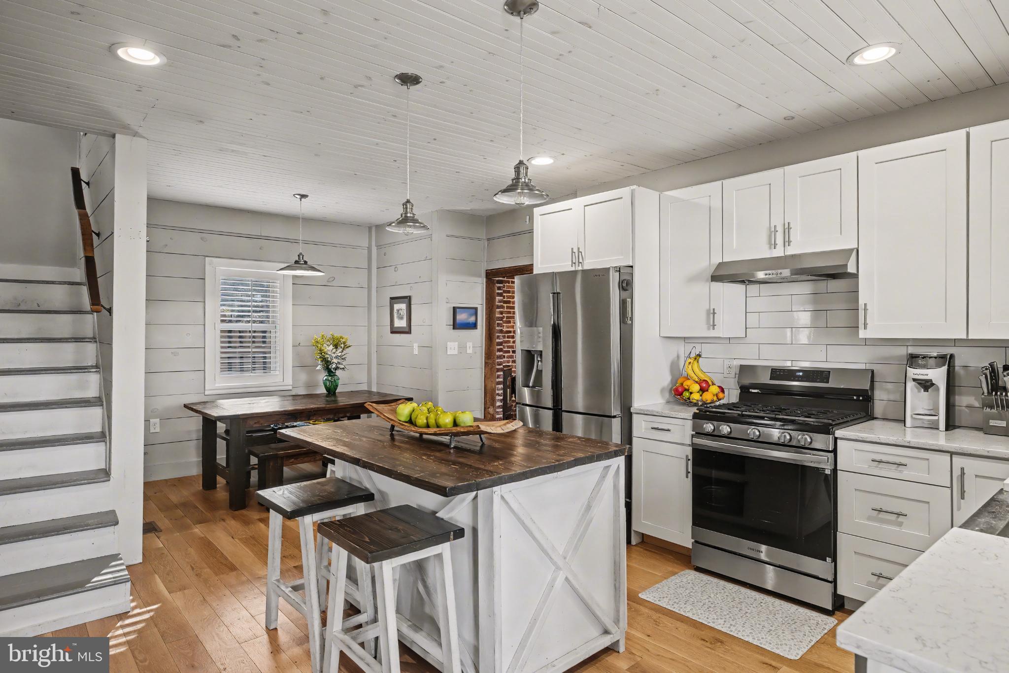 4934 River Road New Hope, PA 18938 - Photo 10 of 56 a kitchen with stainless steel appliances a stove a sink dishwasher a refrigerator white cabinets and wooden floor