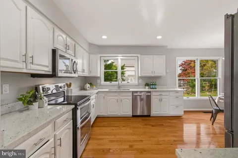 a kitchen with stainless steel appliances granite countertop sink stove top oven and cabinets