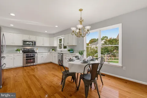 a view of a dining room with furniture a chandelier and wooden floor