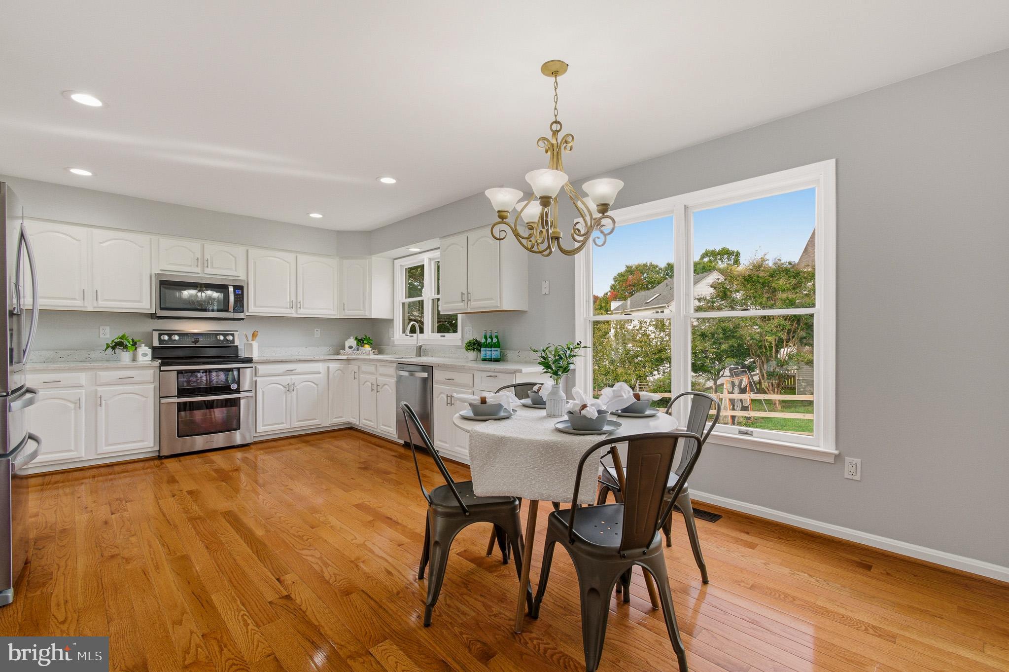 4518 Haywagon Way Ellicott City, MD 21043 - Photo 16 of 54 a view of a dining room with furniture a chandelier and wooden floor