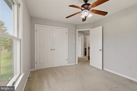 a view of a room with a ceiling fan and a window