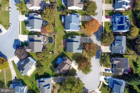 an aerial view of residential houses with outdoor space and trees
