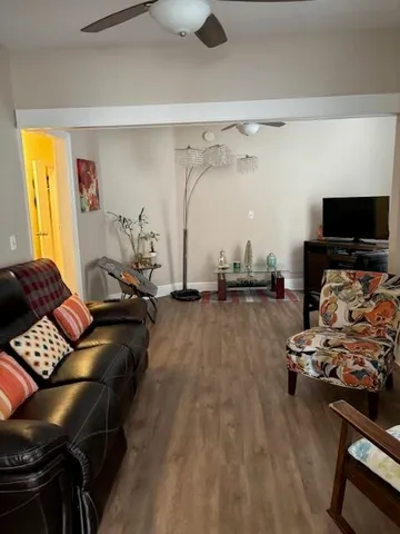 a living room with furniture gym equipment and a flat screen tv