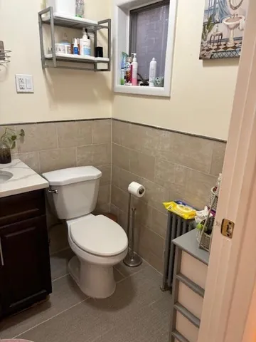 a white toilet sitting next to a bathroom sink and a mirror