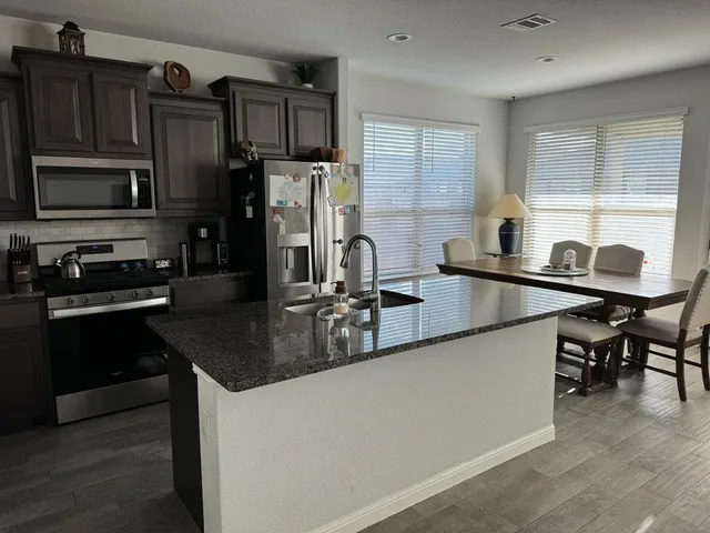 a kitchen with stainless steel appliances granite countertop a sink stove and refrigerator