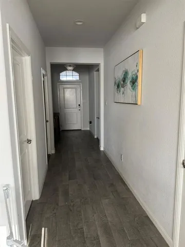a view of a hallway with wooden floor and closet