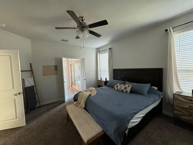 a bedroom with a large bed and a window