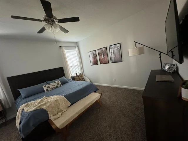 a bedroom with a bed and a flat tv screen on the dresser