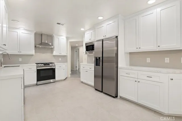 a kitchen with stainless steel appliances white cabinets and a refrigerator