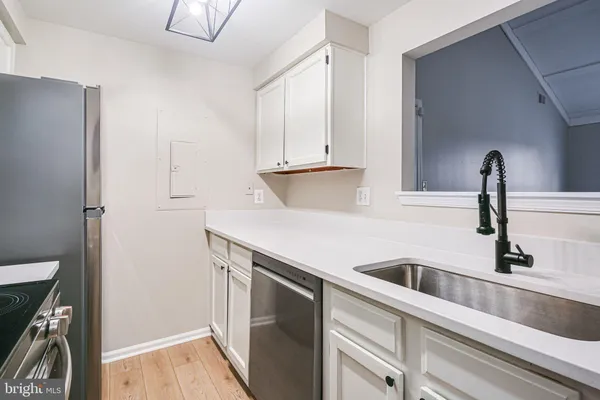 a kitchen with stainless steel appliances granite countertop a sink and a refrigerator