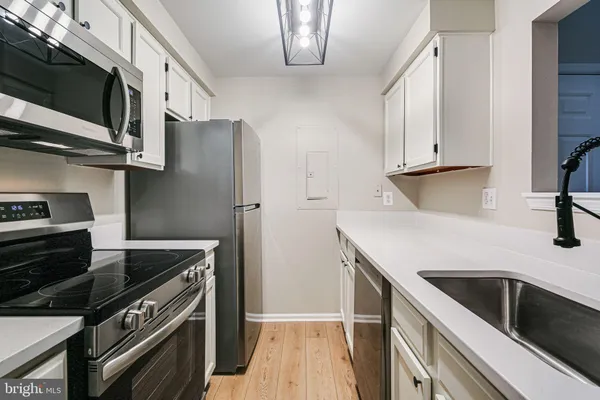 a kitchen with stainless steel appliances a stove microwave and sink